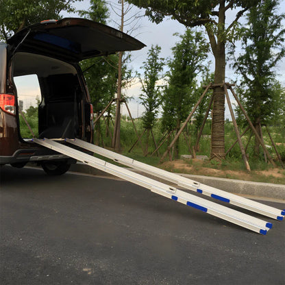 Van with an extended Heeve Telescopic wheelchair ramp on a road with trees in the background